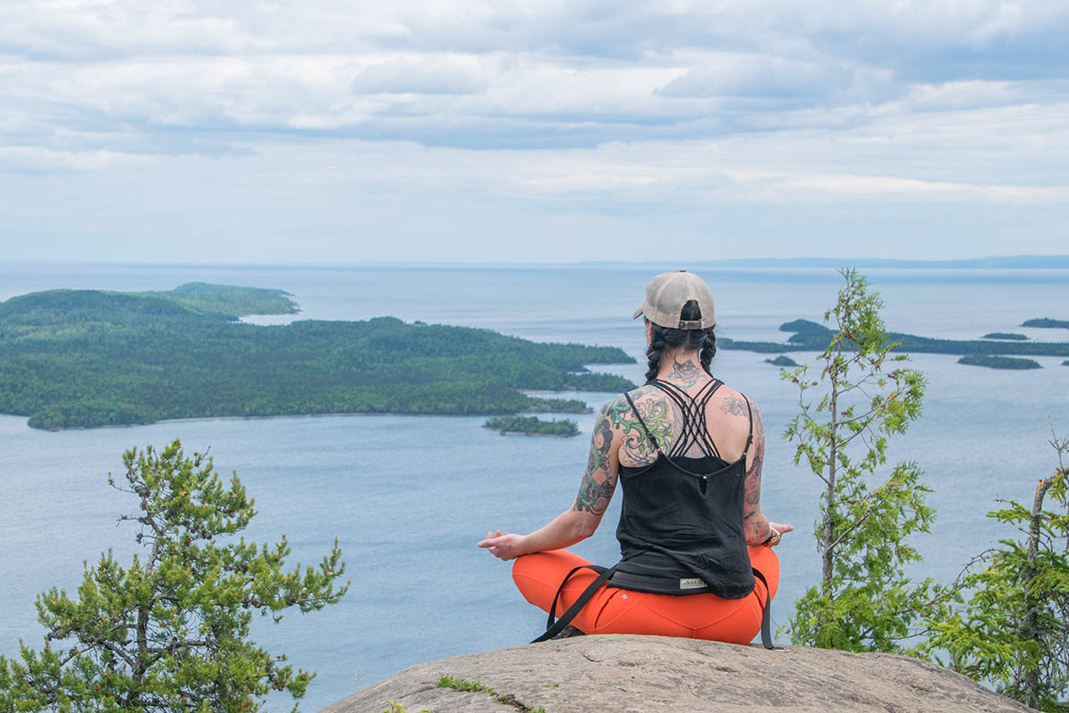 Guest practicing mindfulness while overlooking Lake Superior on hiking trip